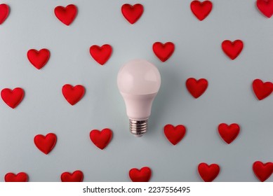 light love concept from hearts around light bulb on blue background minimalism.