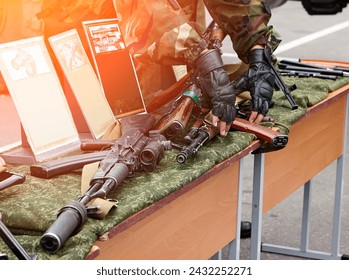 Light machine gun on the table. The soldiers are considering Russian-made weapons.