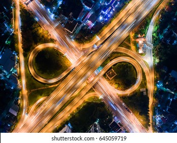 The Light On The Road Roundabout At Night And The City In Bangkok, Thailand. Aerial View. Top View. Background Scenic Road.