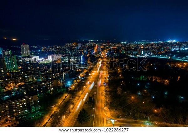 The light on the road roundabout at night and the\
city in Burgas, Bulgaria. Road beautiful Aerial View of Busy\
Intersection, Aerial view. Top view. Background scenic road. curves\
road drone view