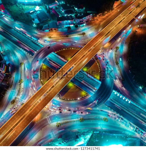 The light on the road roundabout\
at night and the city in Bangkok, Road beautiful Aerial View of\
Busy Intersection, Aerial view. Top view. Background scenic\
road.