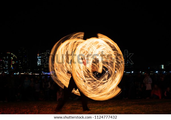 Light painting of a\
street performer of fire in Firelight festival at Docklands,\
Melbourne, Australia 