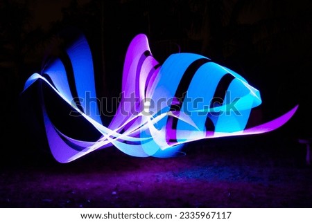 Light painting swirling lines in darkness