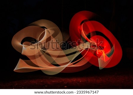 Light painting swirling lines in darkness