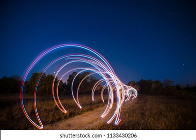 A Light Painting Tunnel Leading The Way Into A Dark Forest By The Night.