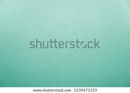 Light pale blue green abstract background with space for design. Mint color. Silk fabric surface.