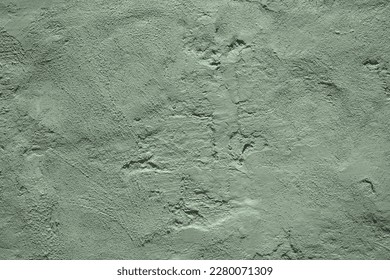 Light pale gray green uneven texture. Painted old concrete wall with plaster. Sage green color. Grunge. Rough surface background for design. Empty. Close-up.