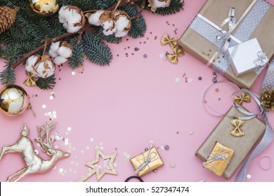 Light pink Christmas, New Year background with sequins, gifts, a branch of fir and cotton.