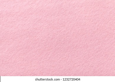 Стоковая фотография: Light pink matte background of suede fabric, closeup. Velvet texture of seamless rose woolen felt.