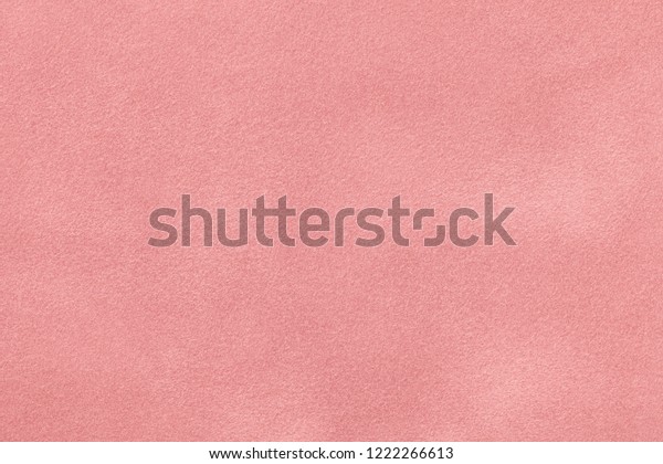 Light pink matte background of\
suede fabric, closeup. Velvet texture of seamless pastel\
leather.