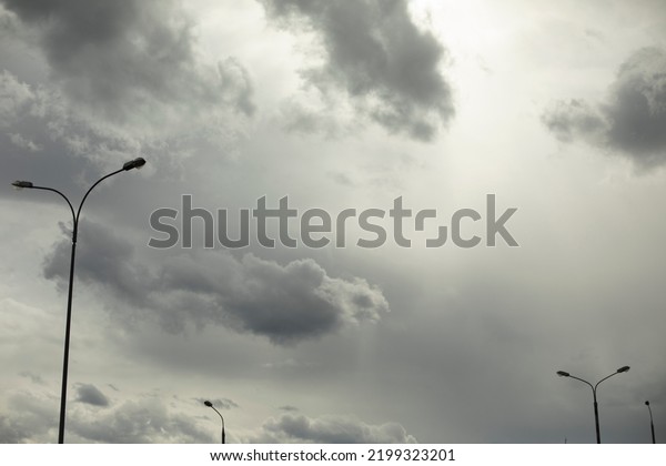 Light pole against sky. Celestial\
landscape in cloudy weather. Minimalism of urban\
environment.