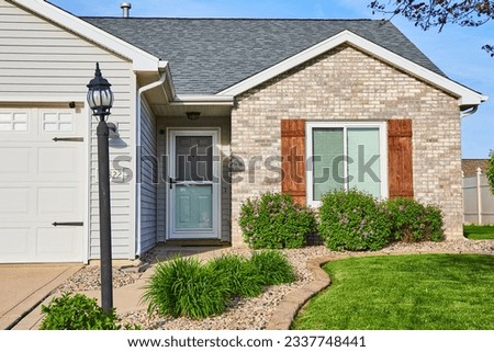 Light pole post, tan, gray bricks, slate gray checkered splotched roof white door rock river path