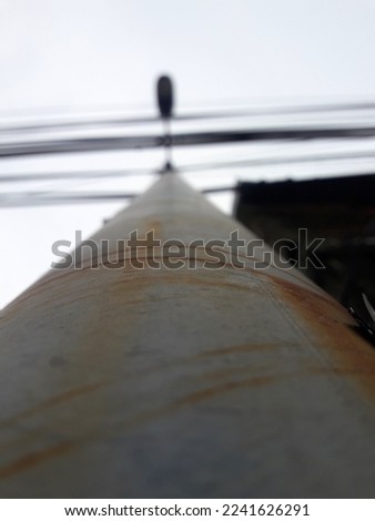 a light pole taken from below and has a little bit rusty surface, and a defocused on the light bulb
