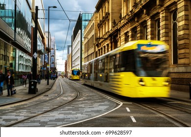 Light rail yellow tram in the city center of Manchester, UK in the evening. It is a popular transportation in Manchester.