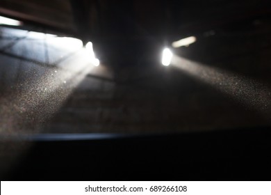 Light Rays Protruding From Ceiling Windows In Old Dark Factory Filled With Dust Particles