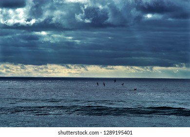 Light rays shining through a break in the clouds over the ocean.