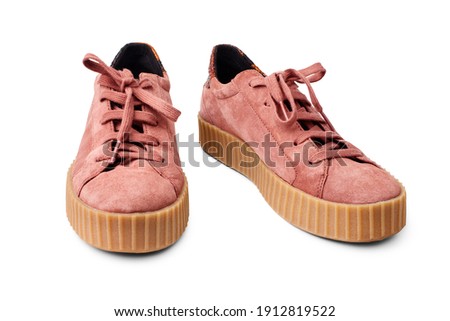 Light red suede sneakers white background isolated close up front view, stylish pink chamois gumshoes, pair of beige leather shoes, two casual boots, fashion slippers, walking footwear, urban footgear