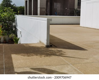 The Light Reflects Off The Concrete Wall Beside The Office Building.