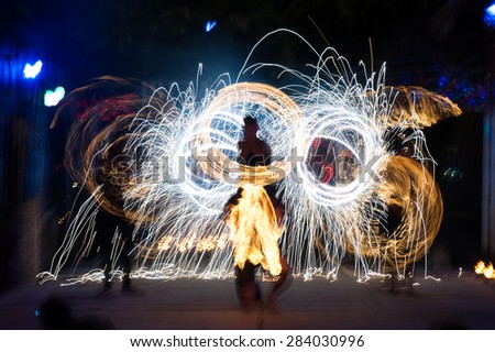 Light rings made during fire performance . Motion blurred