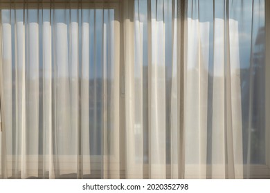 Light and see through concept, Classic white sheer curtains hanging by the window in the room with soft sunlight in the afternoon, Blurred outside view as background. - Shutterstock ID 2020352798