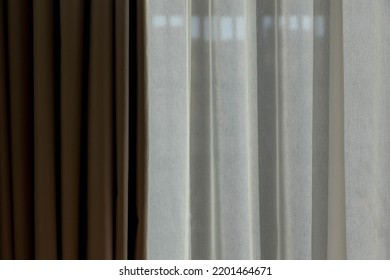 Light And Shadow Concept, Classic See Through White Sheer Curtains Hanging By The Window In The Room With Sunlight And Blurred Outside View, Fabric And Linen Background.