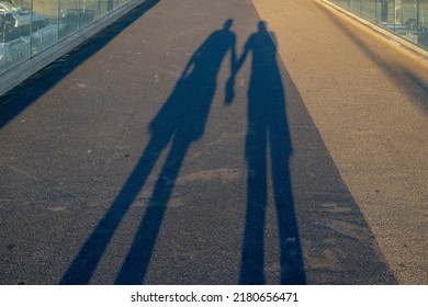 Light and shadow concept, Silhouette of two guys holding hand on the street during the sunset, Gay love couple walking together in the evening with golden sunlight, Love background. - Powered by Shutterstock