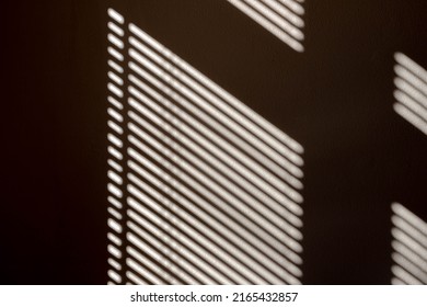 Light and shadow concept, The sunlight shines through the venetian blinds on the concrete wall, Dual toned of black and white in oblique line, Wavy steel stripes design, Abstract background.