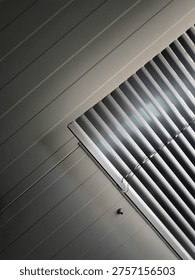 Light and Shadow Play Through Window Blinds Creating Abstract Patterns. This image captures the interplay of light and shadow created by window blinds. 