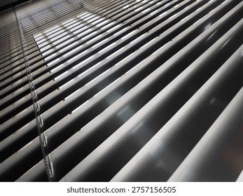 Light and Shadow Play Through Window Blinds Creating Abstract Patterns. This image captures the interplay of light and shadow created by window blinds. 