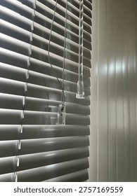 Light and Shadow Play Through Window Blinds Creating Abstract Patterns. This image captures the interplay of light and shadow created by window blinds. 