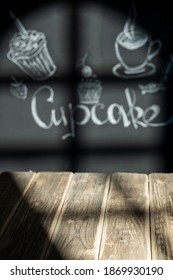 Light   shadow through the window wooden table   walls and inscriptions   chalk drawings  coffee  cupcake