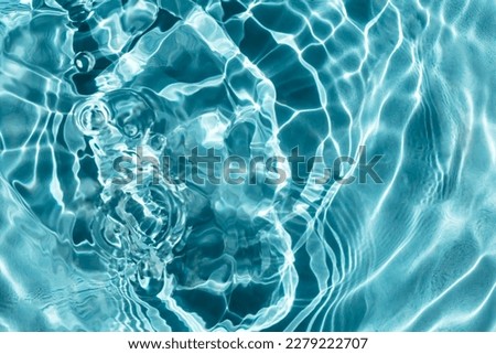 Light shimmers on the waves of clear blue water in the pool. Selective focus, defocus
