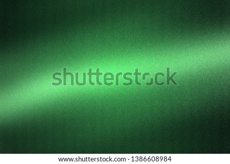 Light shining on green metallic plate in dark room, abstract texture background