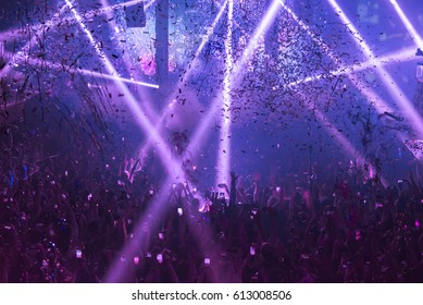Light Show And Silhouette hands of audience crowd people use smart phones enjoying the club party with concert.  Blurry night club DJ party people enjoy of music dancing sound.Abstract Background. - Shutterstock ID 613008506