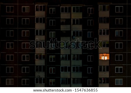 light in a single window. Flat night panorama of multicolor light in windows of multistory buildings. life in big city