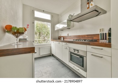 Light Small Home Kitchen With Wide Window Furnished With Cupboards And Shelves With Appliances In Modern Urban Apartment