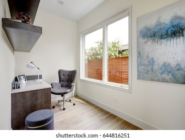 Light Small Home Office Interior With Corner Desk And Grey Upholstered Chair On Hardwood Floor. Northwest, USA