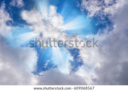 Light or sun rays bursting from the clouds in shape of a cross