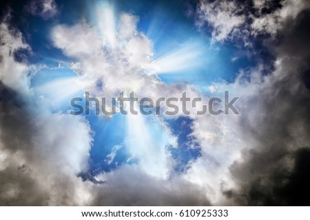 Light or sun rays bursting from the clouds in shape of a cross