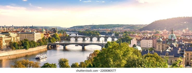 Light Sunset Panorama Of Prague In Warm Colors, European City River With Bridges Connecting Old And New Town