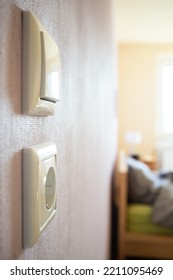 Light Switch And Electrical Outlet Hanging On The Wall Of The Living Room 