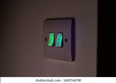 Light Switch Glowing Under UV Light Visualisation Exposing Germs And Viruses Spreading.