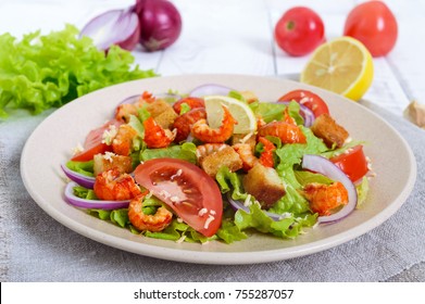 Light Tasty Salad With Meat Of A Cancer, Shrimps, Lettuce, Garlic Croutons, Tomatoes, Red Onions On A White Background.