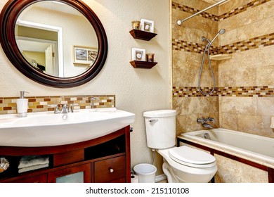 Light Tones Bathroom With Tile Wall Trim. Wooden Vanity Cabinet With White Sink And Round Mirror