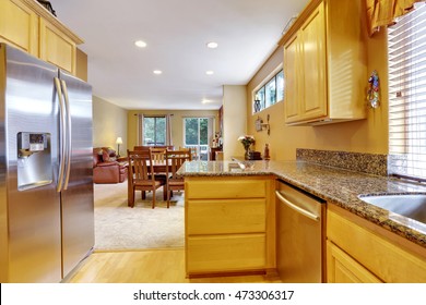 Light Tones Kitchen Interior With Modern Steel Double Doors Fridge. Polished Granite Counter Tops. Dining Room View. Northwest, USA