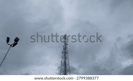 light tower and BTS (base transceiver station) tower under cloudy sky