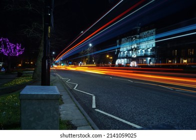 A Light Trail Created By Passing Vehicles Running Down A Busy Road At Night Time. 