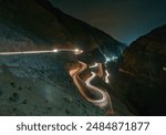 light trail of a moving vehicle on a winding road in Dades Gorge, Morocco                               