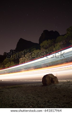 Light trails of a car on side of mountain