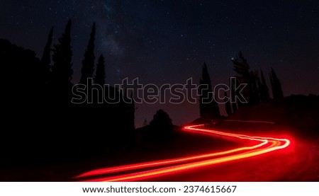Light trails from cars moving fast late in the evening. Concept of high speed.
